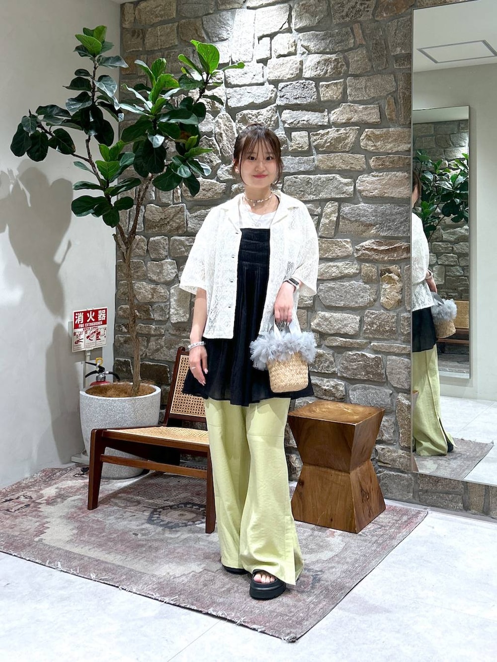 ブラック系のサンダル、グレー系のかごバッグ、イエロー系のその他パンツを着用したレディースの春コーディネートの2枚目の写真