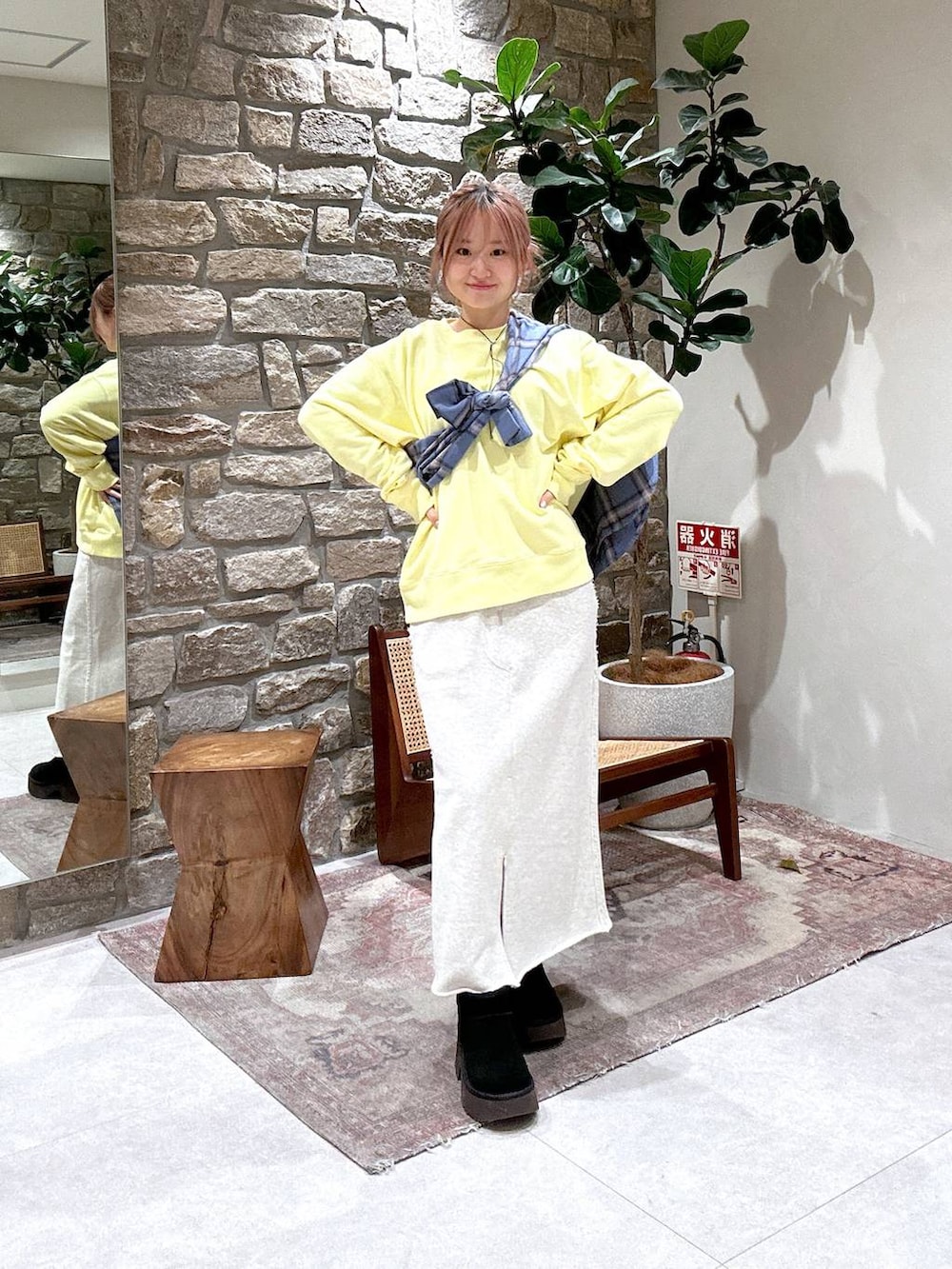 ベージュ系のスカート、イエロー系のスウェットを着用したレディースの冬コーディネートの2枚目の写真