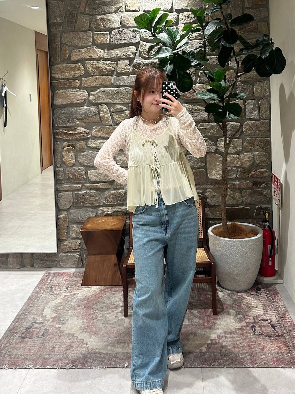 ブルー系のデニムパンツ、ブラック系のTシャツ/カットソー、ホワイト系のキャミソールを着用したレディースの夏コーディネートの2枚目の写真