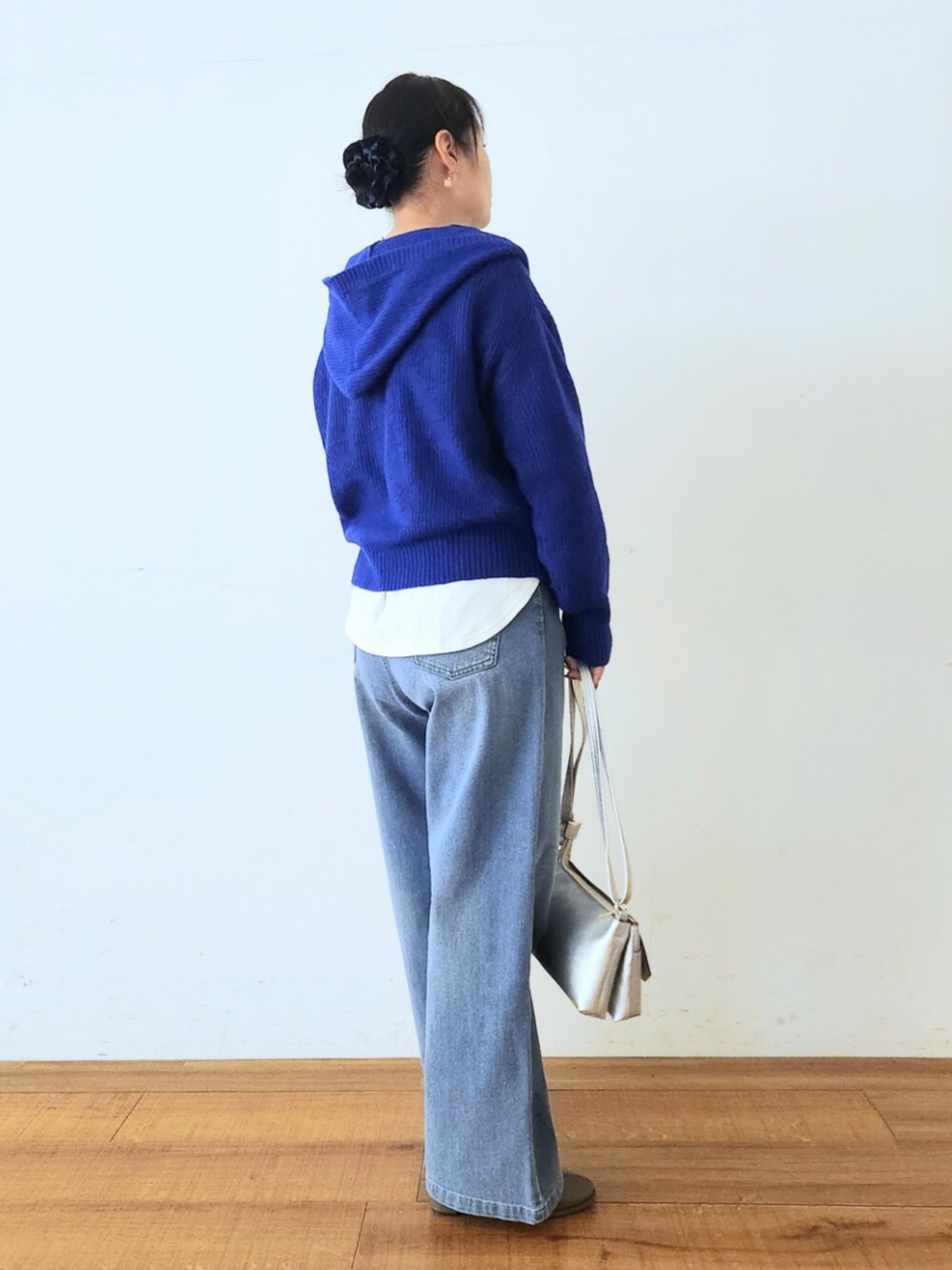 シルバー系のショルダーバッグ、ブラウン系のブーツ、ブルー系のニット/セーターを着用したレディースの秋コーディネートの2枚目の写真