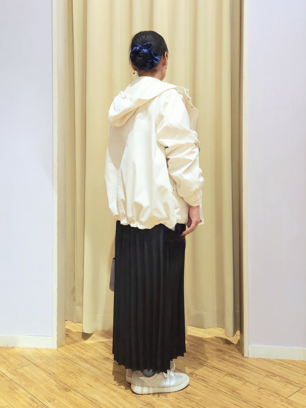 シルバー系のスニーカー、ブルー系のスカート、グレー系のショルダーバッグを着用したレディースの春コーディネートの3枚目の写真