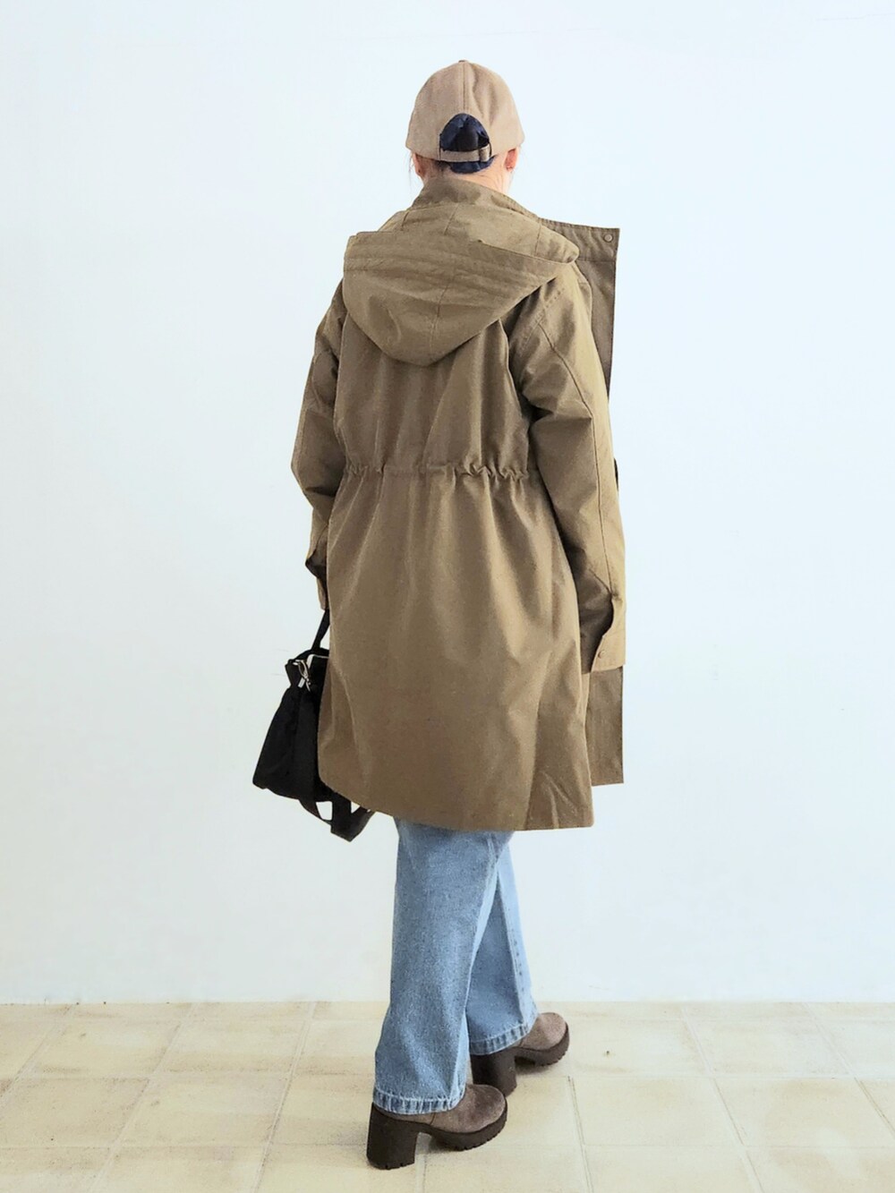 ブルー系のデニムパンツ、ブラウン系のブーツ、ブラック系のトートバッグを着用したレディースの秋コーディネートの3枚目の写真