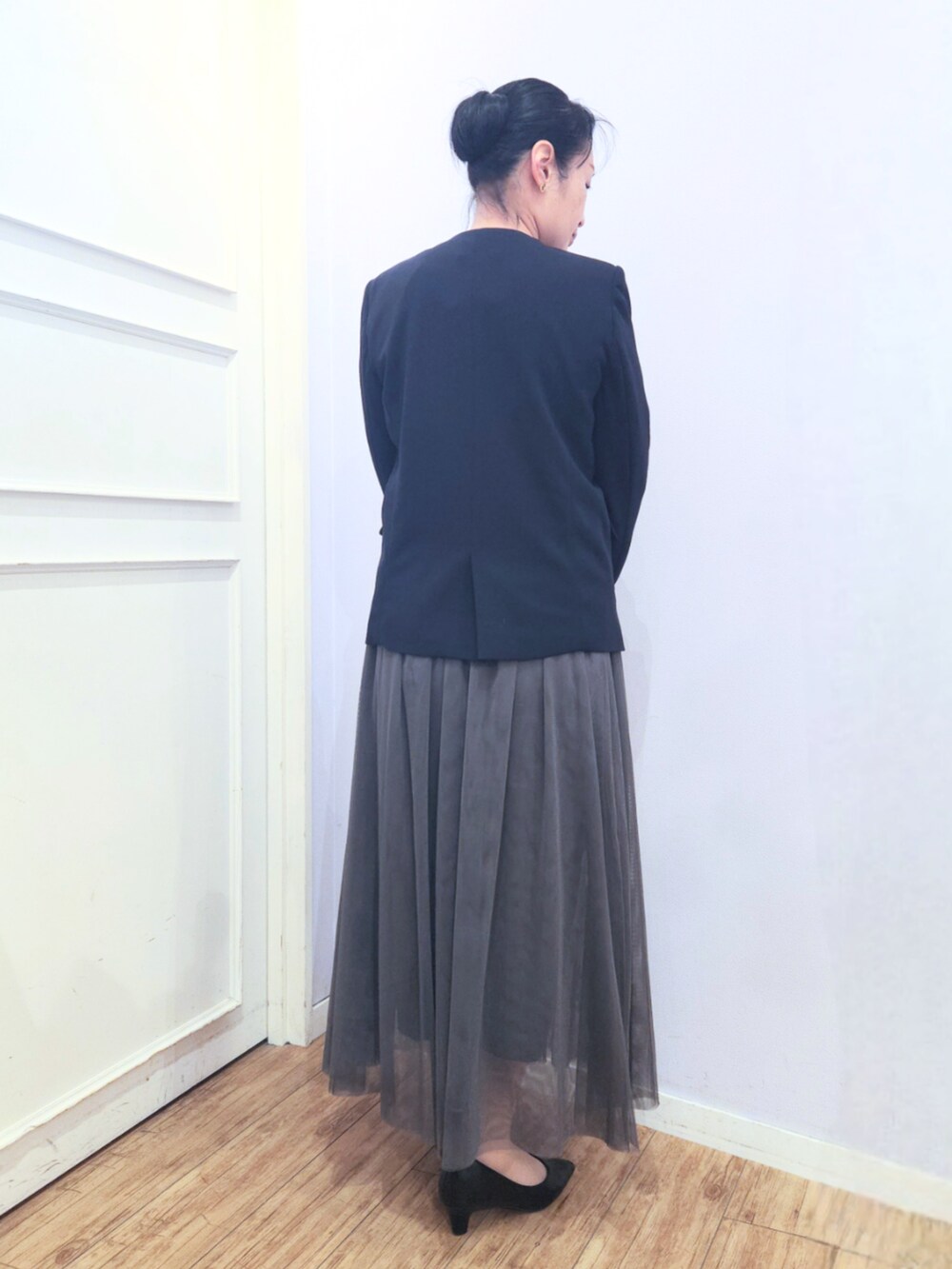 グレー系のトートバッグ、ブラック系のパンプス、グレー系のスカートを着用したレディースの冬コーディネートの3枚目の写真