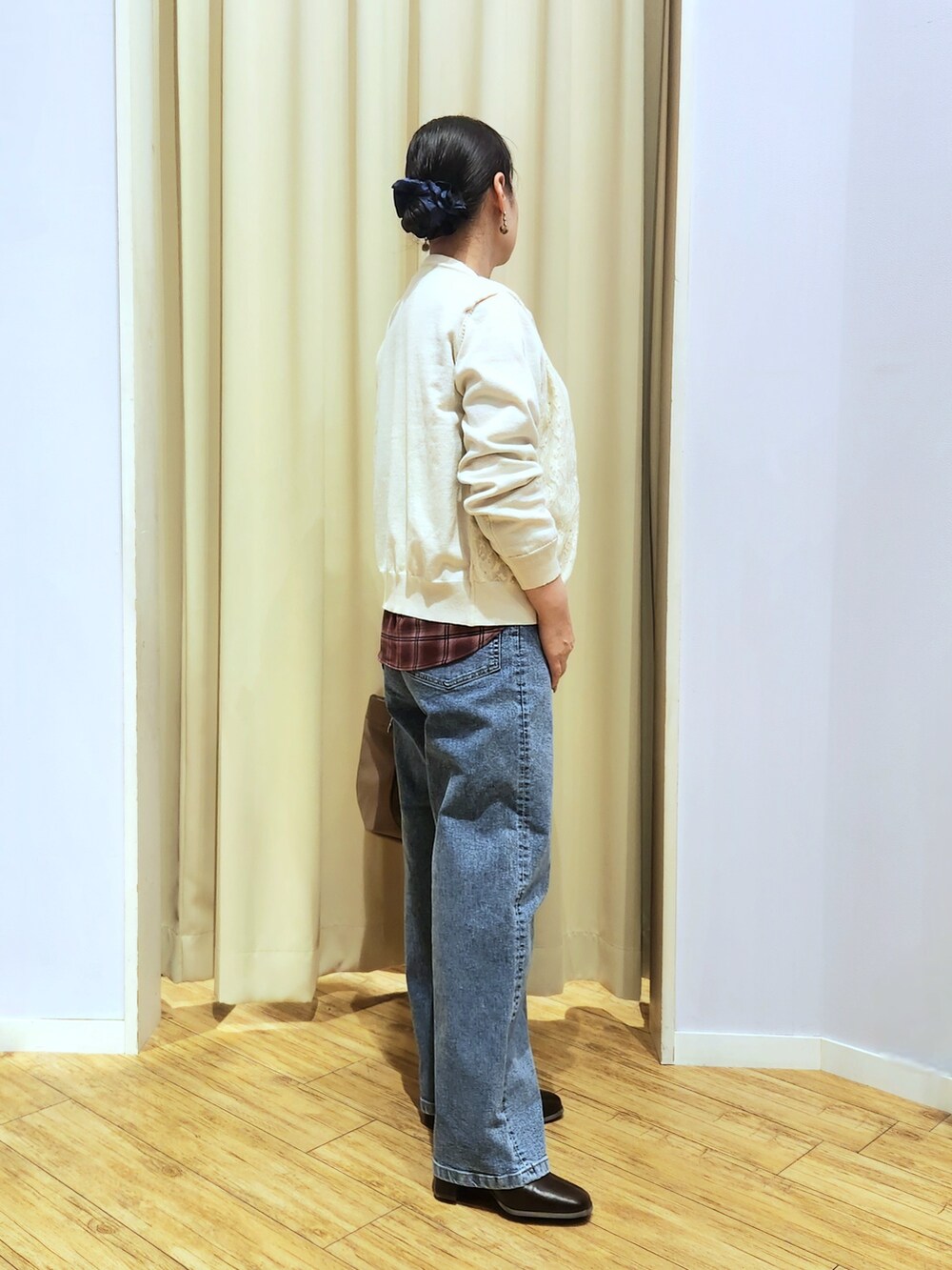 レッド系のシャツ/ブラウス、ホワイト系のカーディガン/ボレロ、ブルー系のデニムパンツを着用したレディースの秋コーディネートの3枚目の写真