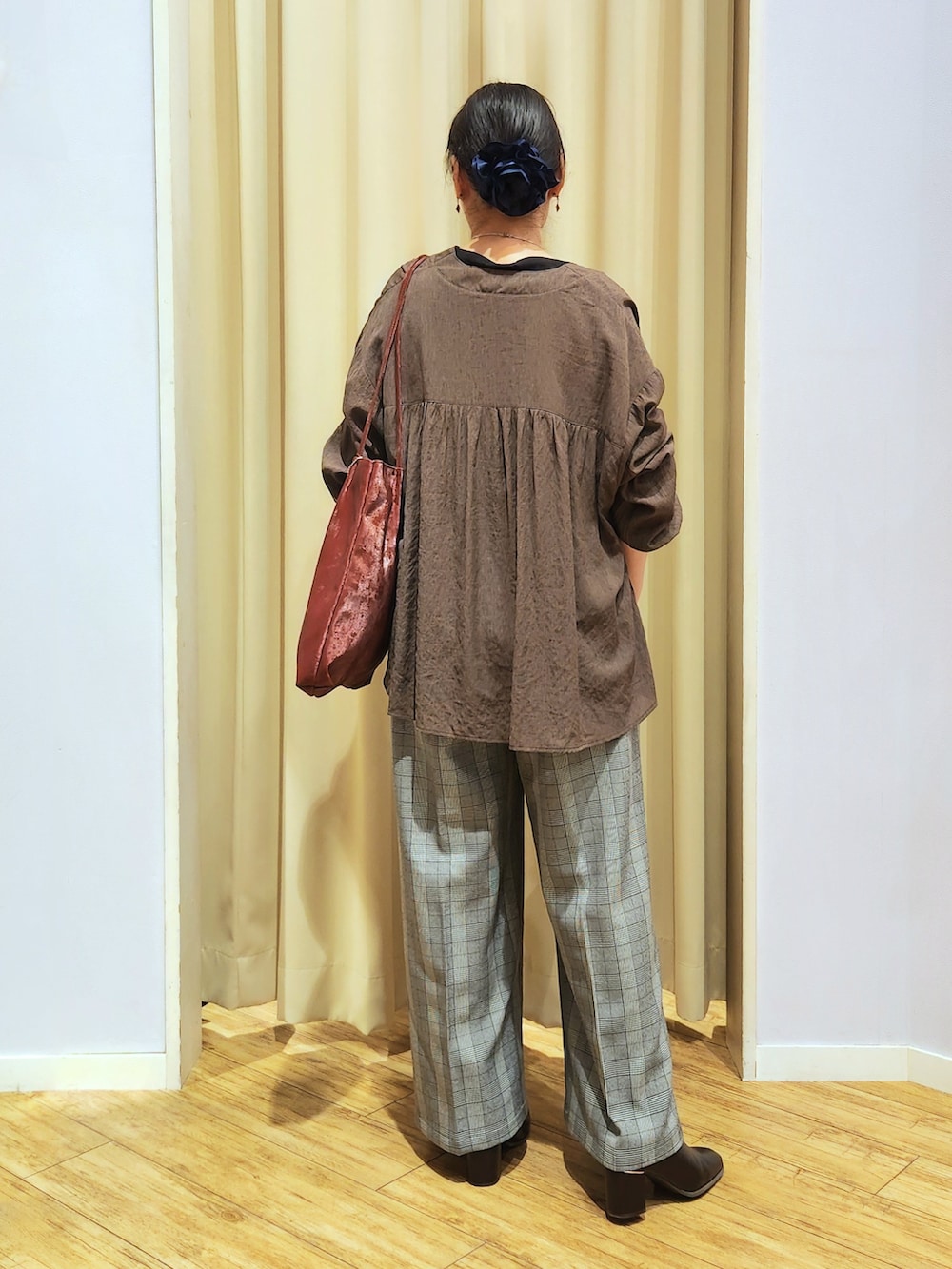 ブラック系のTシャツ/カットソー、グレー系のその他パンツ、ブラウン系のブーツを着用したレディースの秋コーディネートの6枚目の写真
