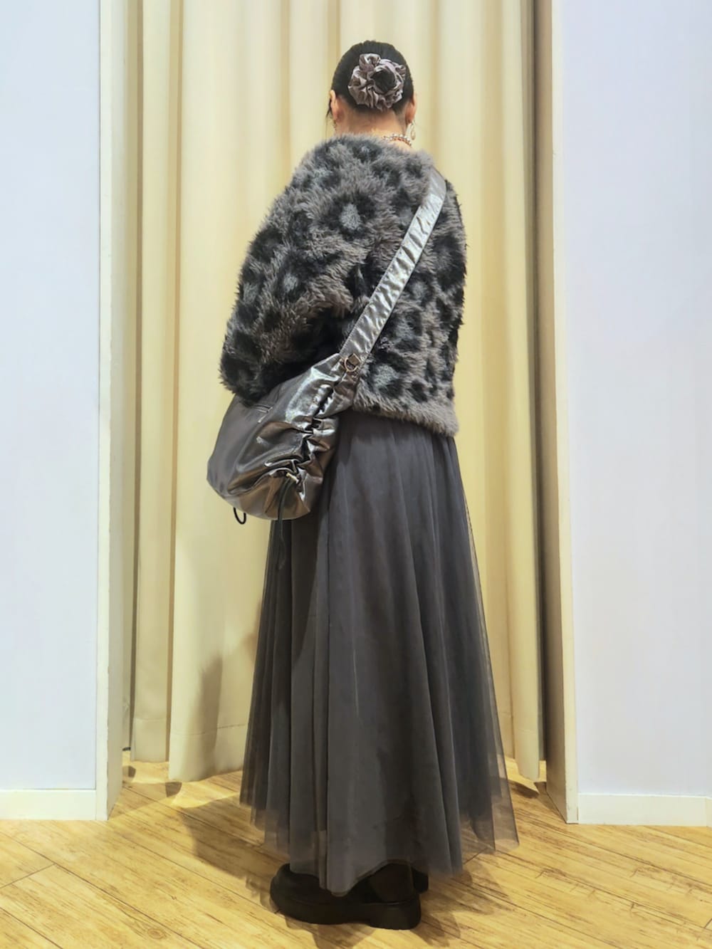 ブラック系のブーツ、グレー系のスカート、グレー系のショルダーバッグを着用したレディースの秋コーディネートの3枚目の写真