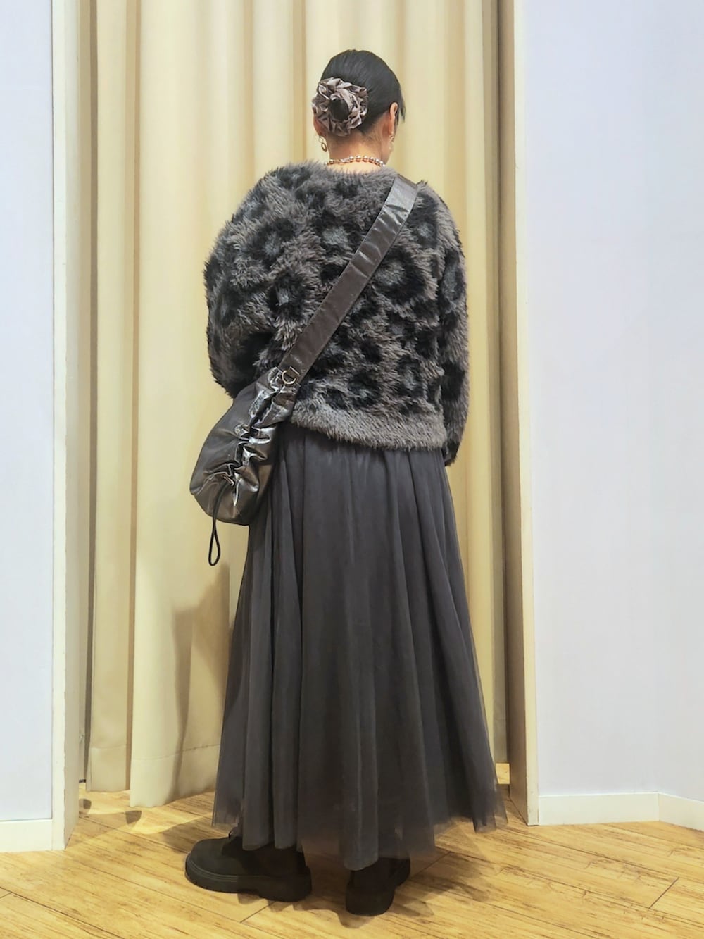 ブラック系のブーツ、グレー系のスカート、グレー系のショルダーバッグを着用したレディースの秋コーディネートの4枚目の写真