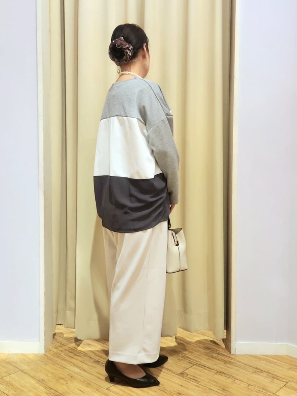 ブラック系のパンプス、グレー系のトートバッグ、ベージュ系のその他パンツを着用したレディースの冬コーディネートの2枚目の写真