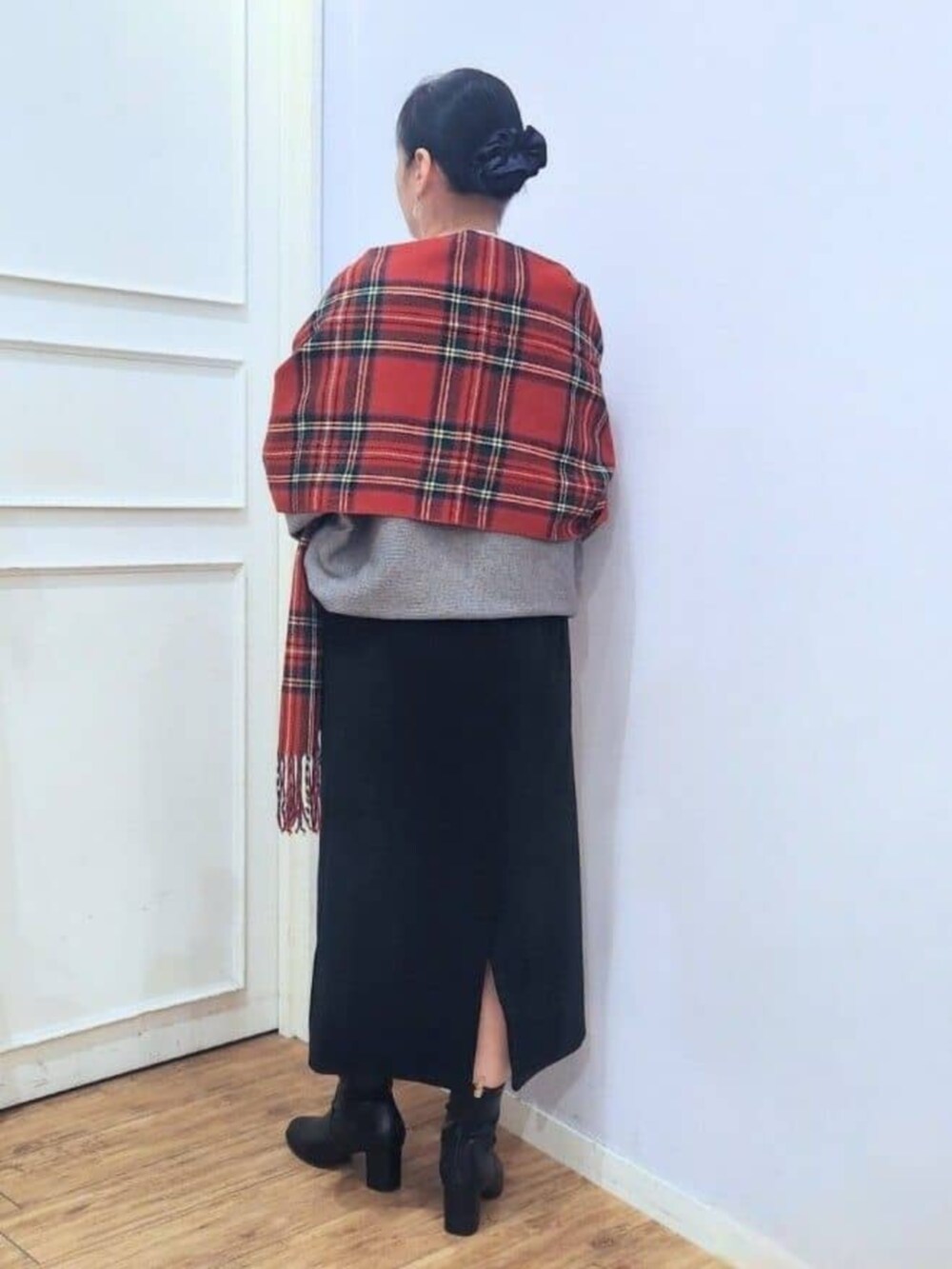 ブラック系のブーツ、グレー系のニット/セーター、ブラック系のスカートを着用したレディースの秋コーディネートの3枚目の写真