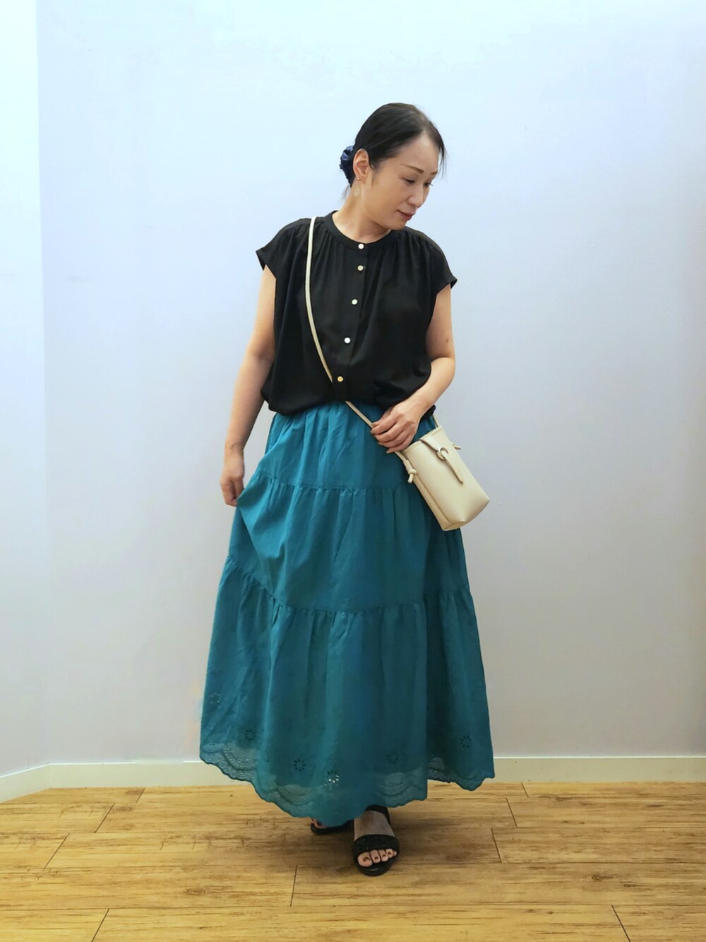 グレー系のショルダーバッグ、グリーン系のスカート、ブラック系のシャツ/ブラウスを着用したレディースの夏コーディネートの4枚目の写真