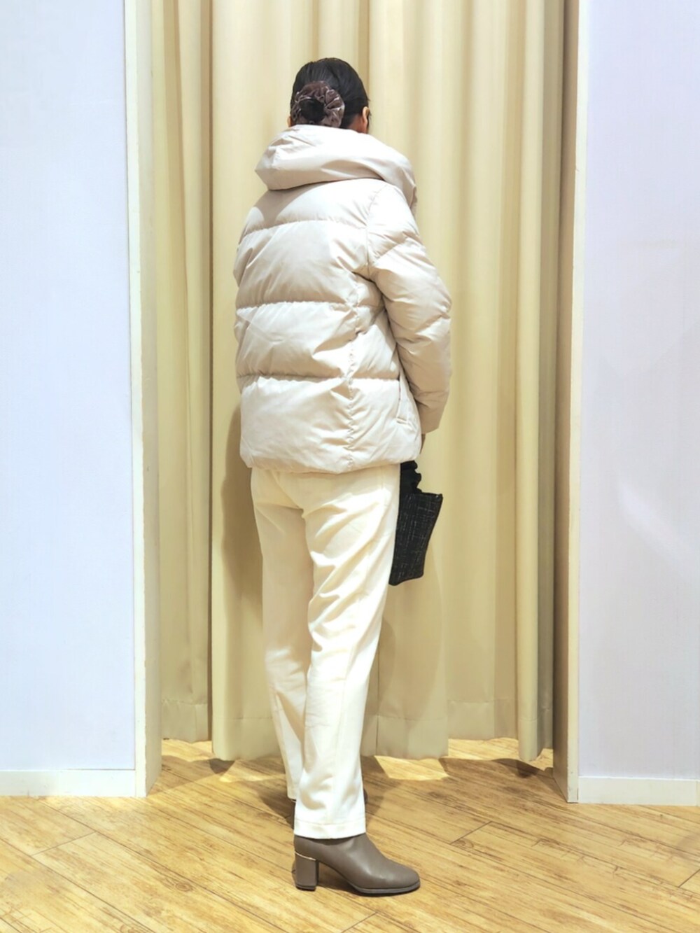 ブラウン系のブーツ、ベージュ系のダウンジャケット/コート、ホワイト系のその他パンツを着用したレディースの冬コーディネートの3枚目の写真