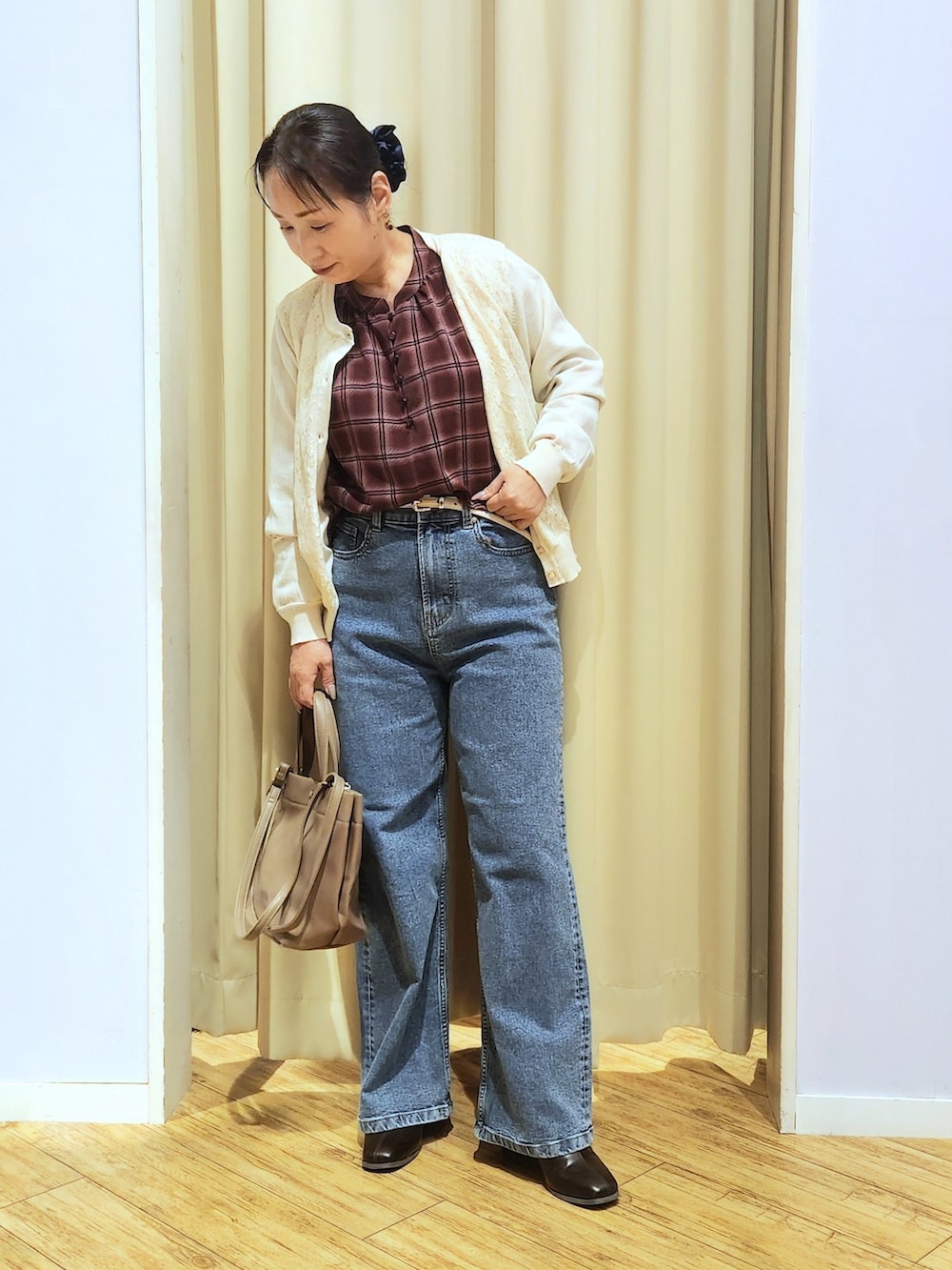 レッド系のシャツ/ブラウス、ホワイト系のカーディガン/ボレロ、ブルー系のデニムパンツを着用したレディースの秋コーディネートの2枚目の写真