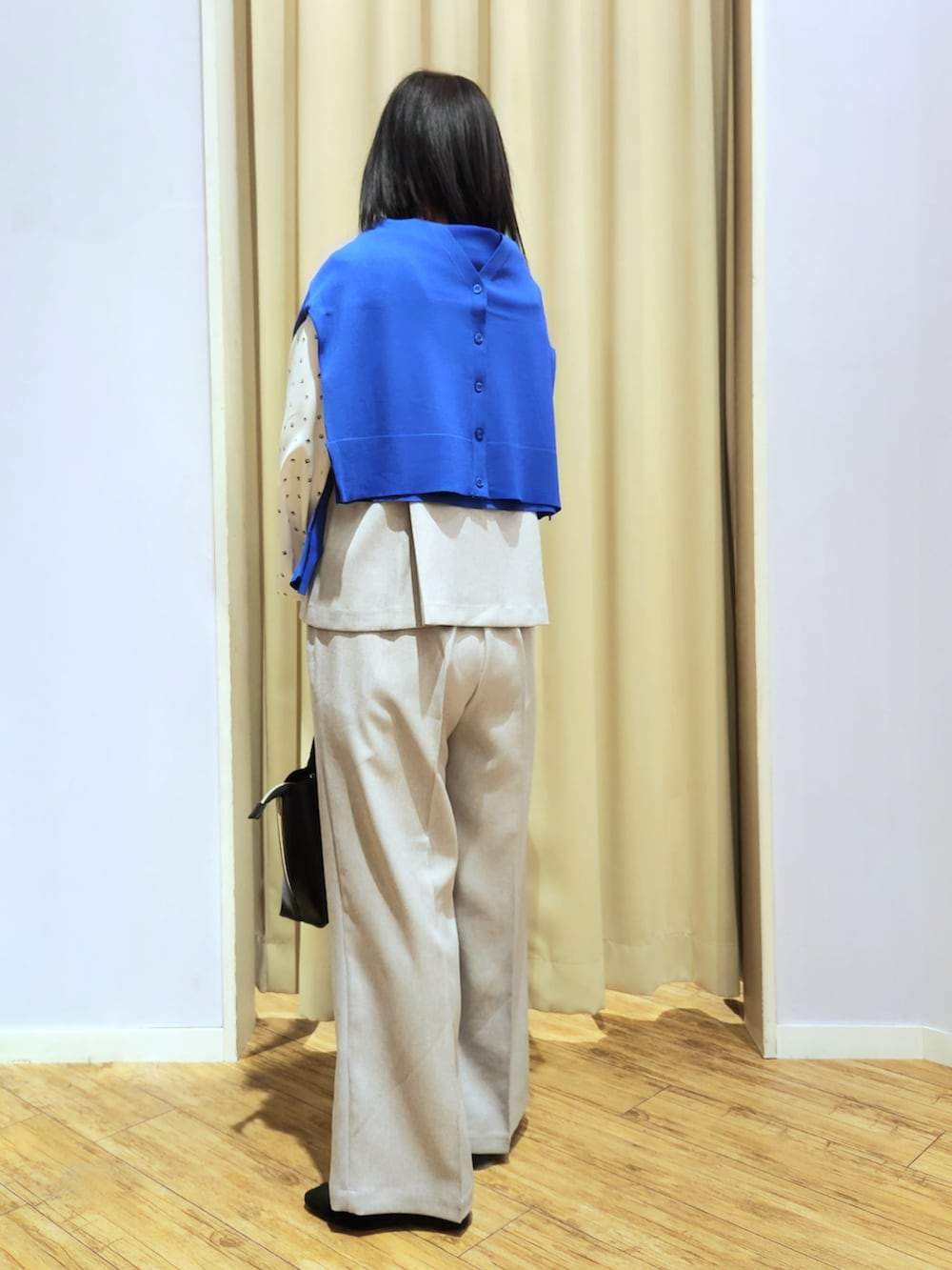 ブラック系のトートバッグ、ブラック系のパンプス、グレー系のパンツドレスを着用したレディースの春コーディネートの3枚目の写真