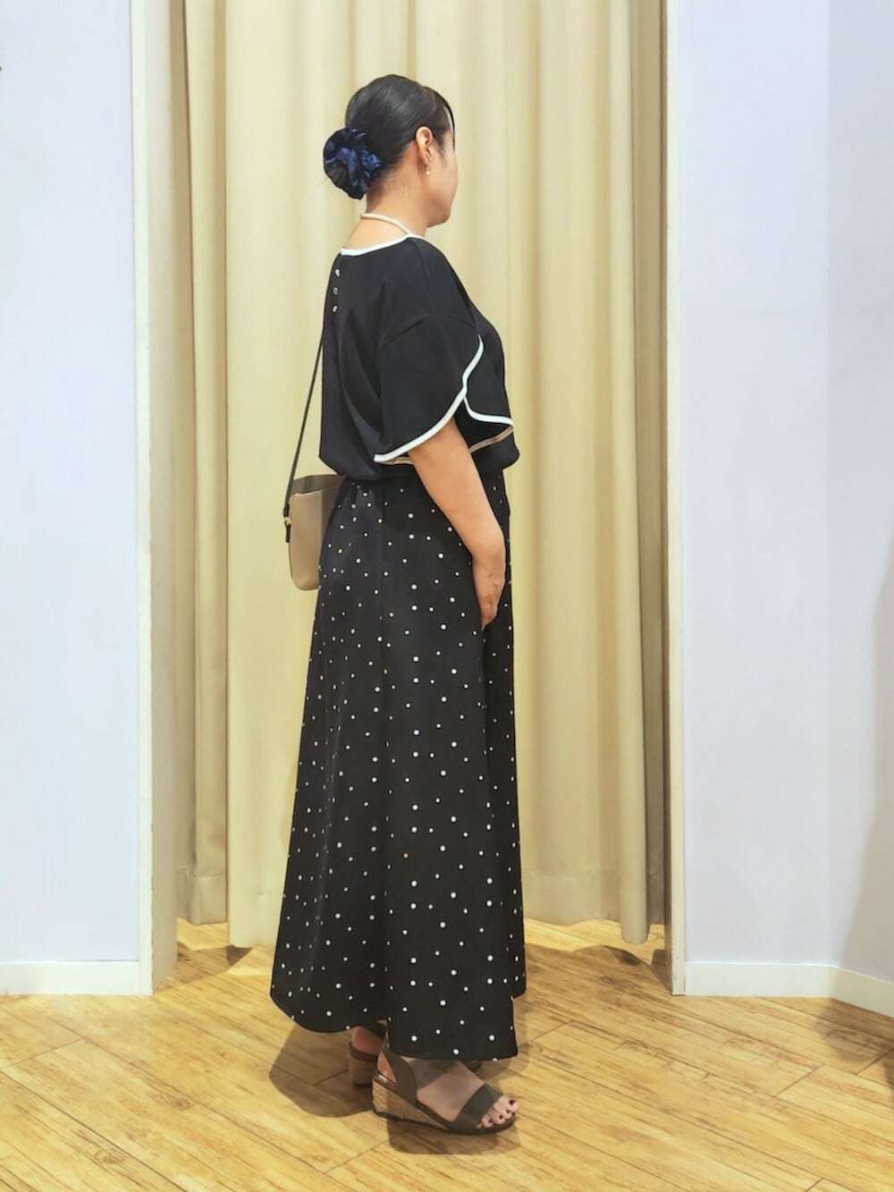 ブラウン系のサンダル、ベージュ系のショルダーバッグ、ブラック系のTシャツ/カットソーを着用したレディースの夏コーディネートの2枚目の写真