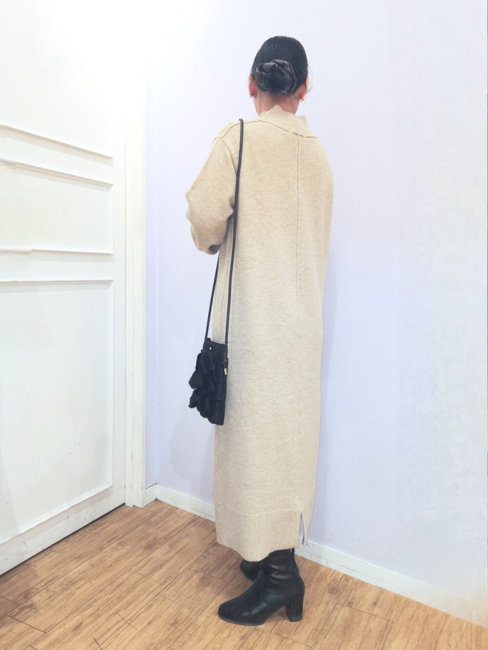 ブラック系のブーツ、ブラック系のショルダーバッグ、ベージュ系のワンピースを着用したレディースの冬コーディネートの3枚目の写真