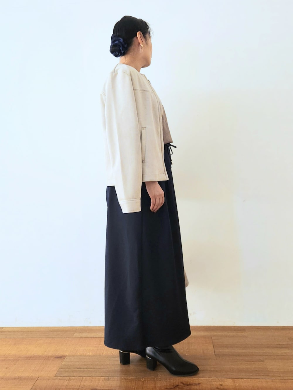 ブラック系のブーツ、ブルー系のその他パンツ、ブラウン系のニット/セーターを着用したレディースの秋コーディネートの2枚目の写真