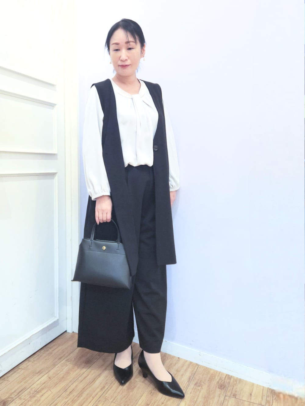 ブラック系のパンプス、ブラック系のベスト、ブラック系のその他パンツを着用したレディースの冬コーディネートの5枚目の写真