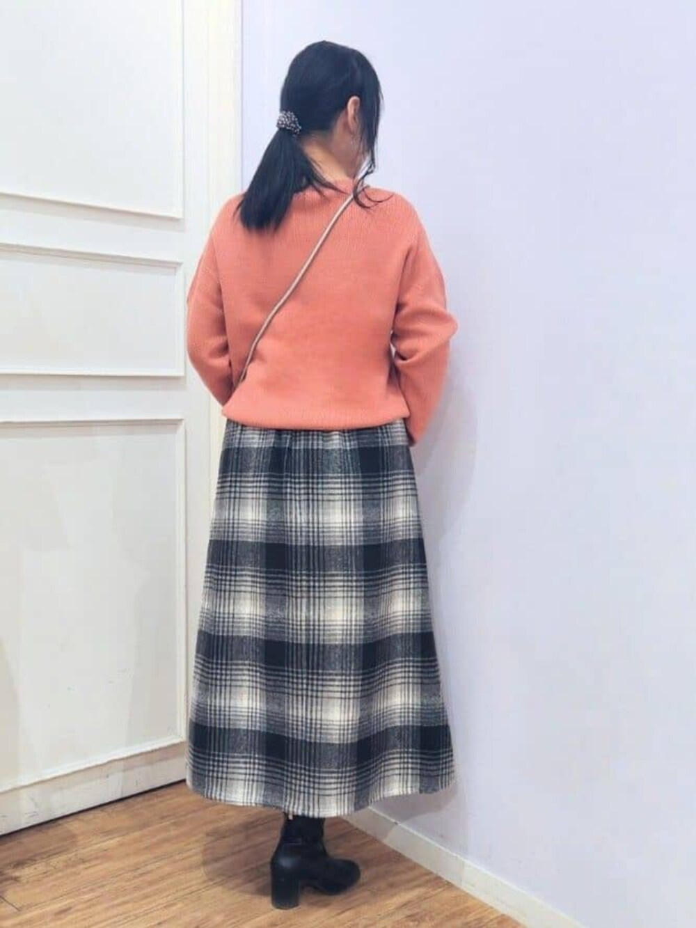 ブラック系のブーツ、ピンク系のニット/セーター、ブラック系のスカートを着用したレディースの秋コーディネートの3枚目の写真