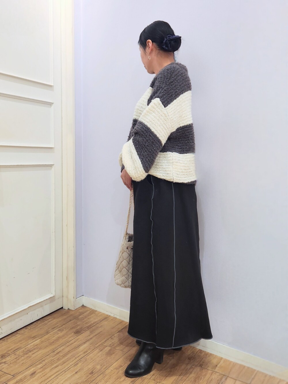 ブラック系のブーツ、ベージュ系のショルダーバッグ、グレー系のニット/セーターを着用したレディースの秋コーディネートの2枚目の写真