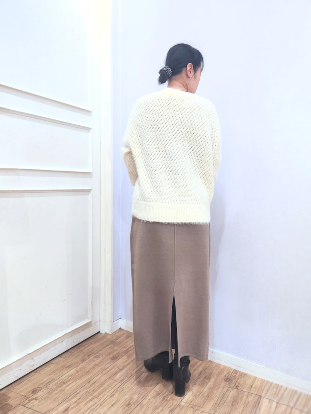 ホワイト系のニット/セーター、ブラック系のブーツ、ベージュ系のトートバッグを着用したレディースの冬コーディネートの3枚目の写真