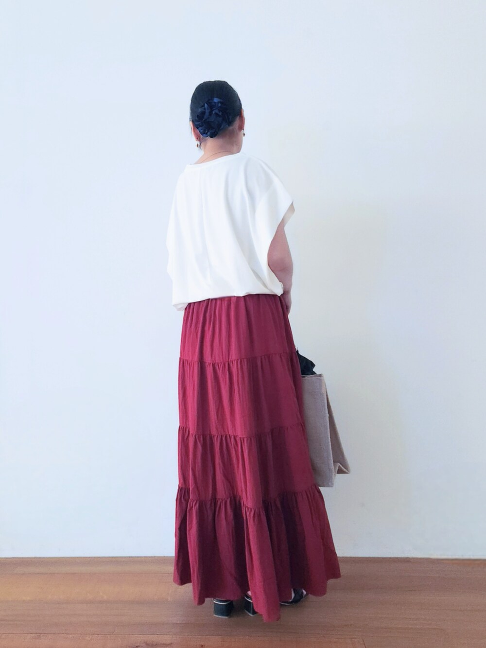 ブラック系のトートバッグ、レッド系のスカート、ホワイト系のTシャツ/カットソーを着用したレディースの夏コーディネートの4枚目の写真