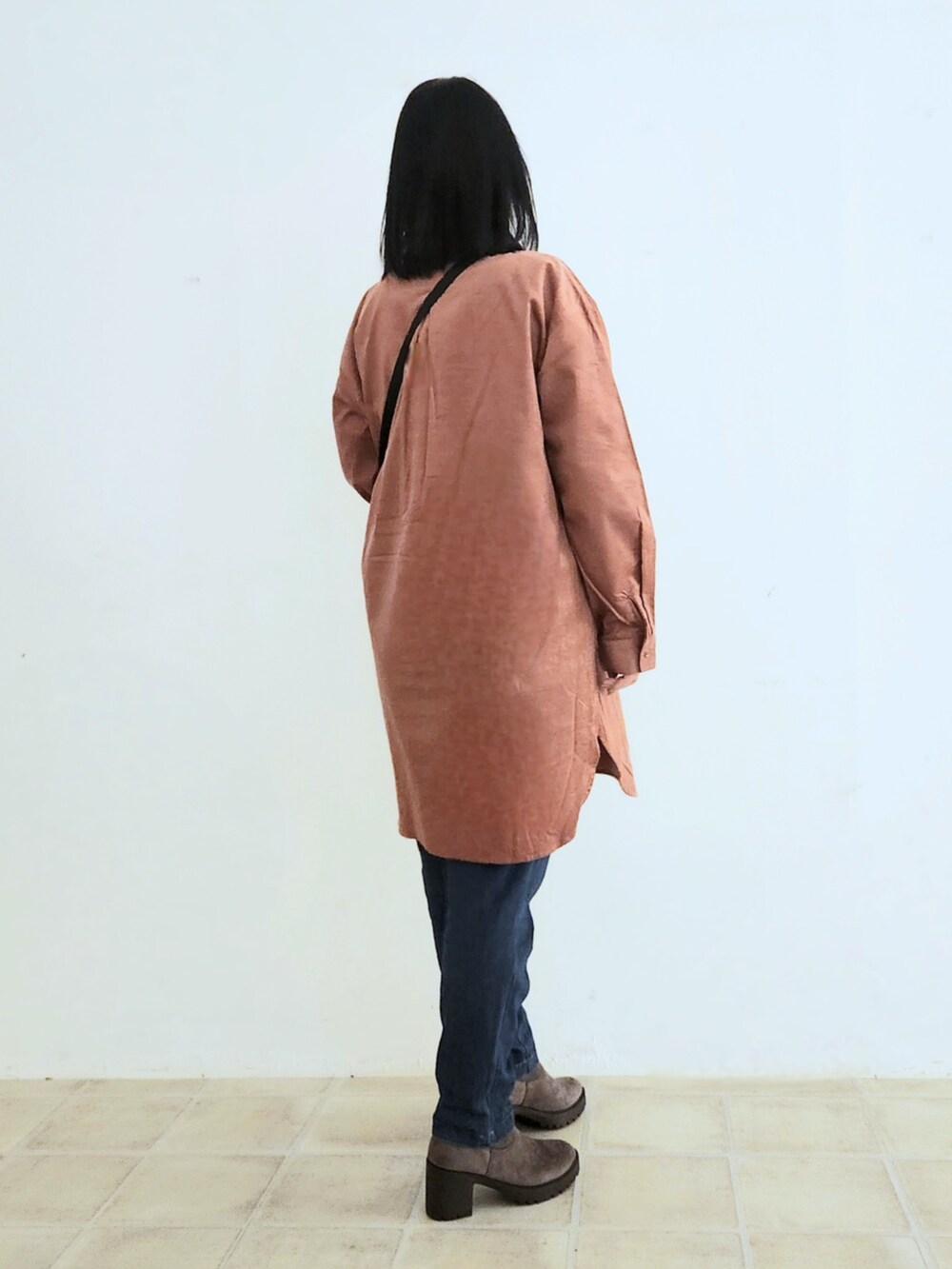 ブルー系のデニムパンツ、ブラック系のTシャツ/カットソー、ピンク系のチュニックを着用したレディースの秋コーディネートの3枚目の写真