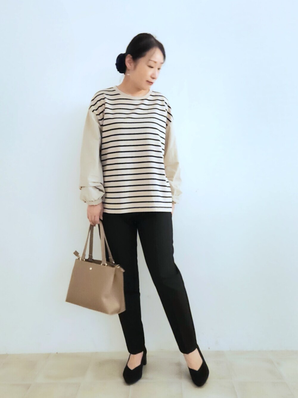 ブラック系のパンプス、ブラウン系のテーラードジャケット、ベージュ系のTシャツ/カットソーを着用したレディースの秋コーディネートの5枚目の写真