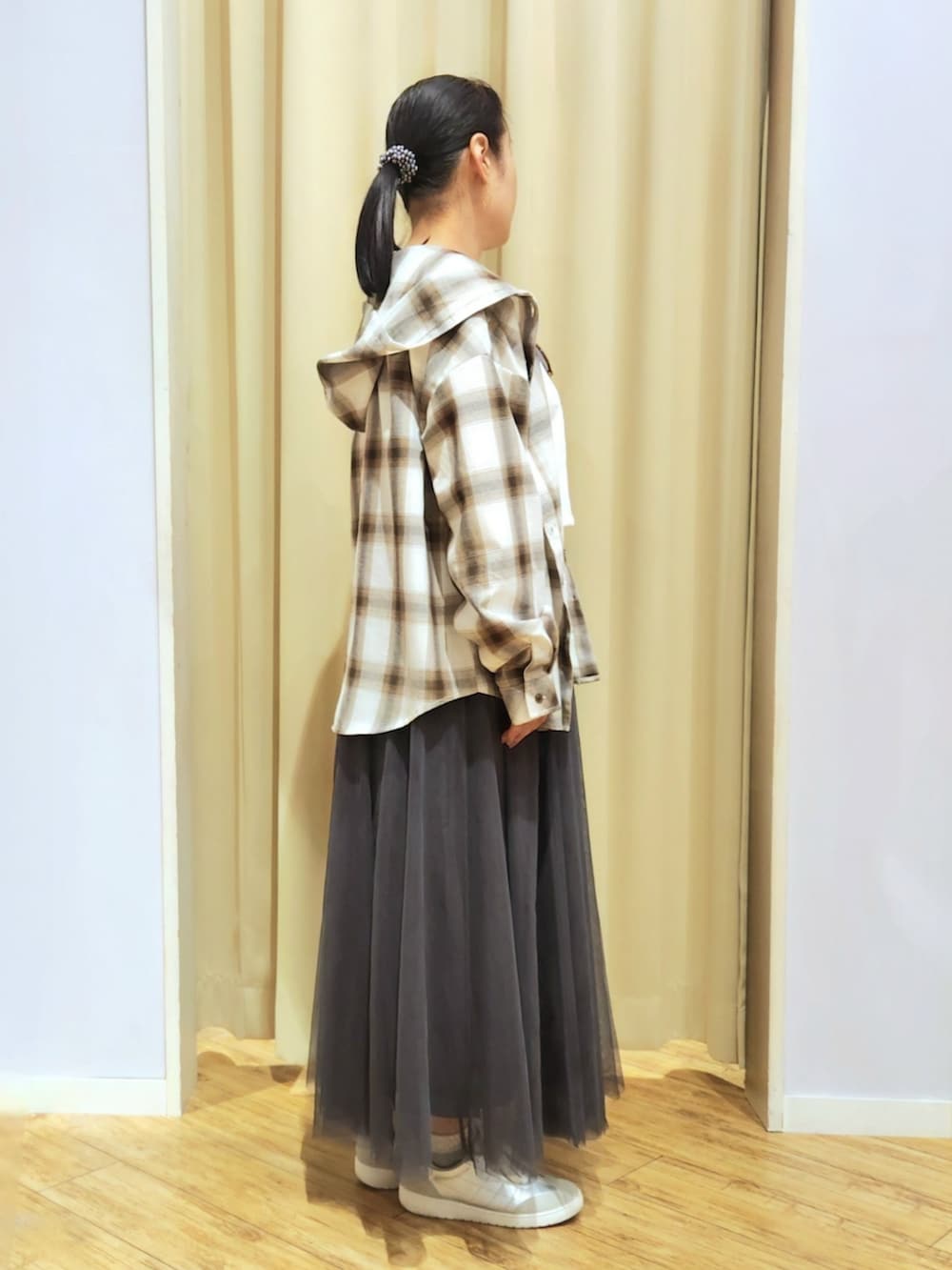 グレー系のスカート、シルバー系のショルダーバッグ、シルバー系のスニーカーを着用したレディースの春コーディネートの2枚目の写真