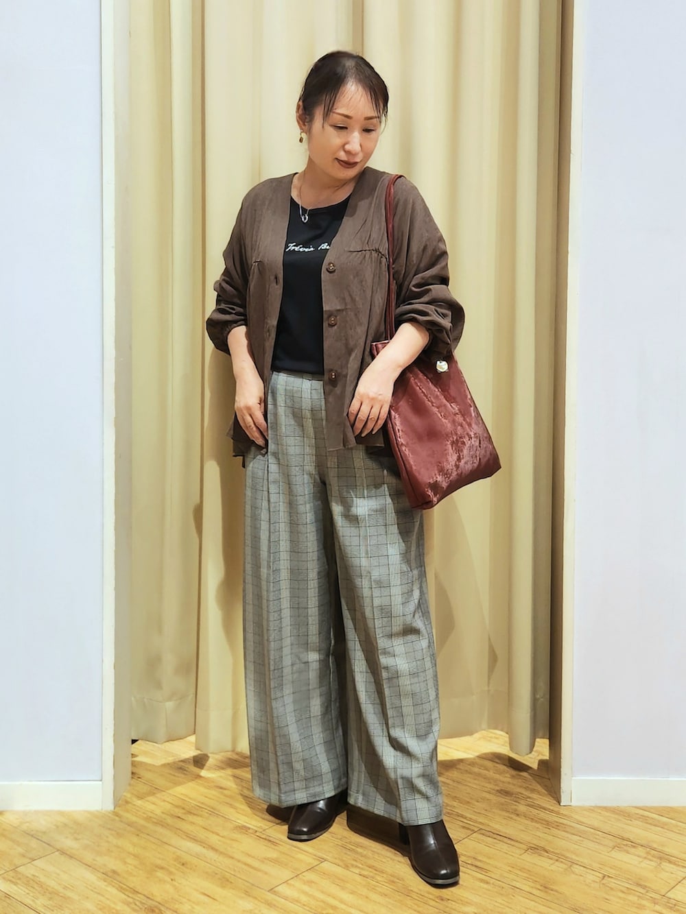 ブラック系のTシャツ/カットソー、グレー系のその他パンツ、ブラウン系のブーツを着用したレディースの秋コーディネートの2枚目の写真