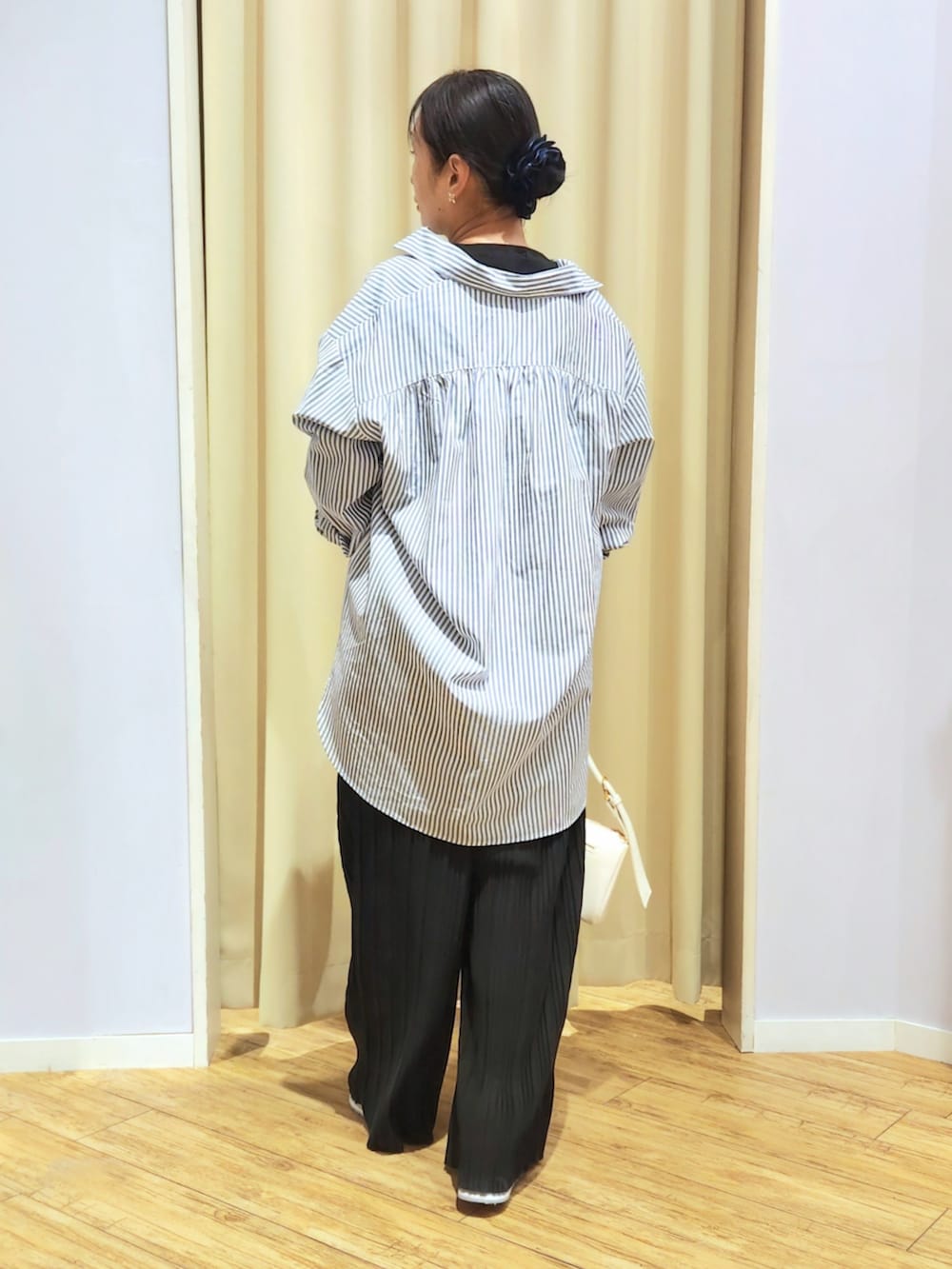 ホワイト系のショルダーバッグ、ホワイト系のTシャツ/カットソー、ホワイト系のスニーカーを着用したレディースの春コーディネートの3枚目の写真