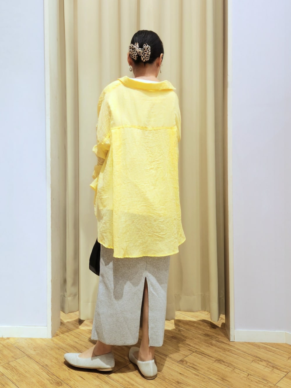 ベージュ系のパンプス、グレー系のスカート、ブラック系のショルダーバッグを着用したレディースの春コーディネートの3枚目の写真