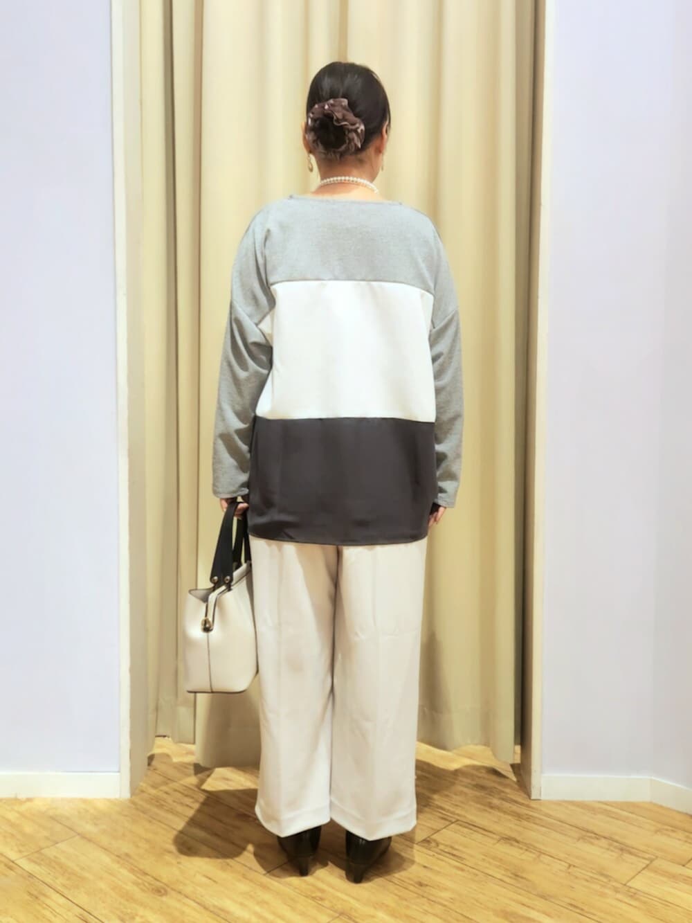 ブラック系のパンプス、グレー系のトートバッグ、ベージュ系のその他パンツを着用したレディースの冬コーディネートの4枚目の写真