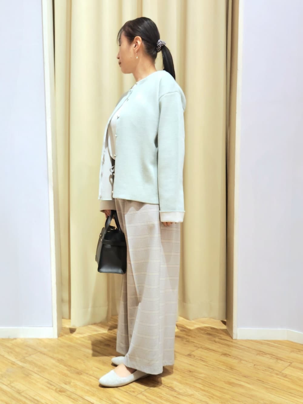 ブルー系のその他パンツ、ベージュ系のパンプス、ブラック系のショルダーバッグを着用したレディースの冬コーディネートの2枚目の写真