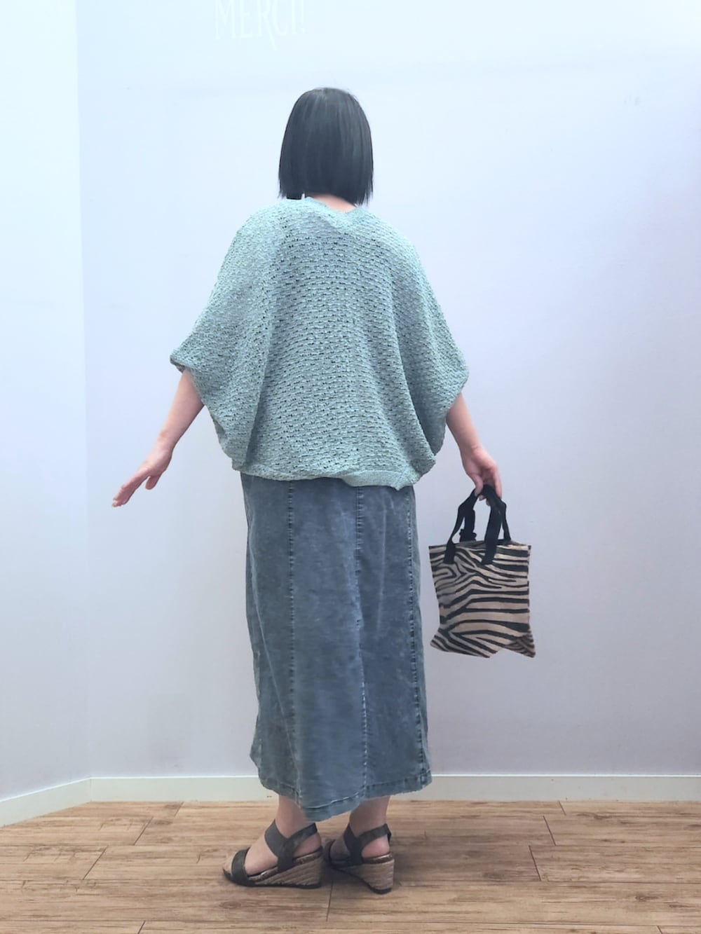 ブラック系のトートバッグ、その他のサンダル、ブルー系のワンピースを着用したレディースの春コーディネートの4枚目の写真