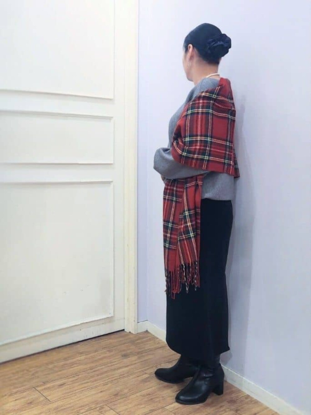 ブラック系のブーツ、グレー系のニット/セーター、ブラック系のスカートを着用したレディースの秋コーディネートの2枚目の写真