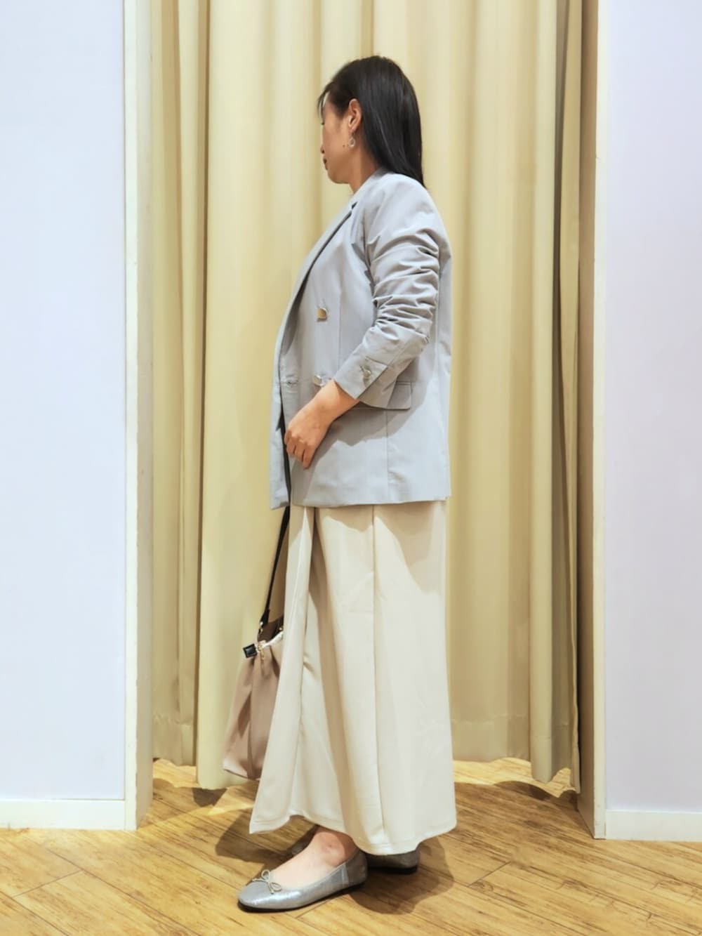 シルバー系のその他シューズ、ベージュ系のトートバッグ、ベージュ系のスカートを着用したレディースの春コーディネートの2枚目の写真