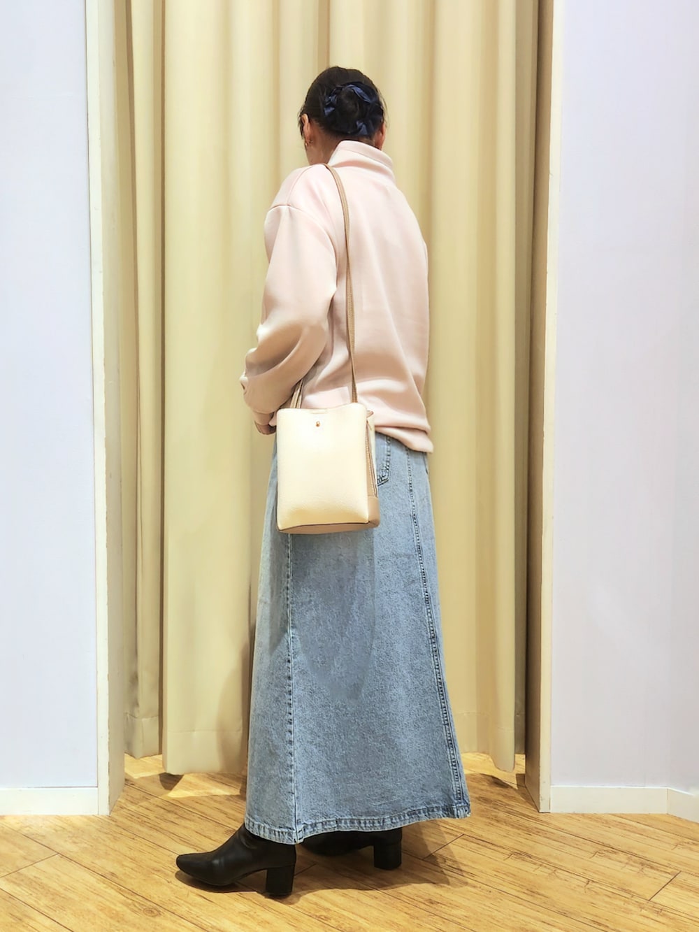 ブルー系のデニムスカート、ベージュ系のショルダーバッグ、ピンク系のTシャツ/カットソーを着用したレディースの冬コーディネートの3枚目の写真