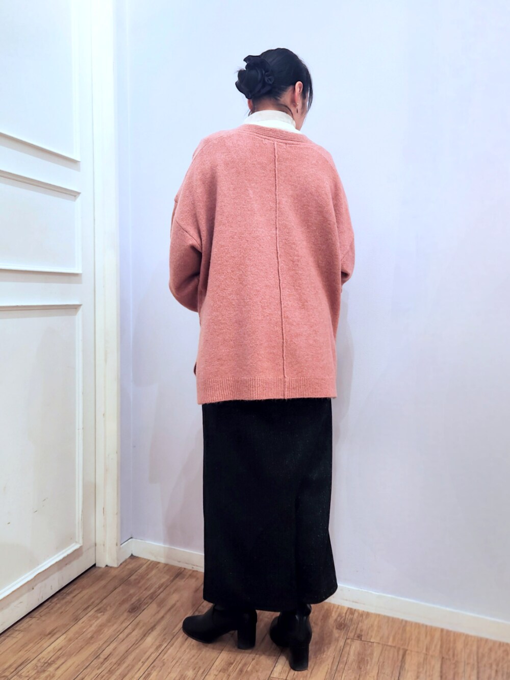 ブラック系のブーツ、ブラック系のスカート、ピンク系のニット/セーターを着用したレディースの冬コーディネートの3枚目の写真