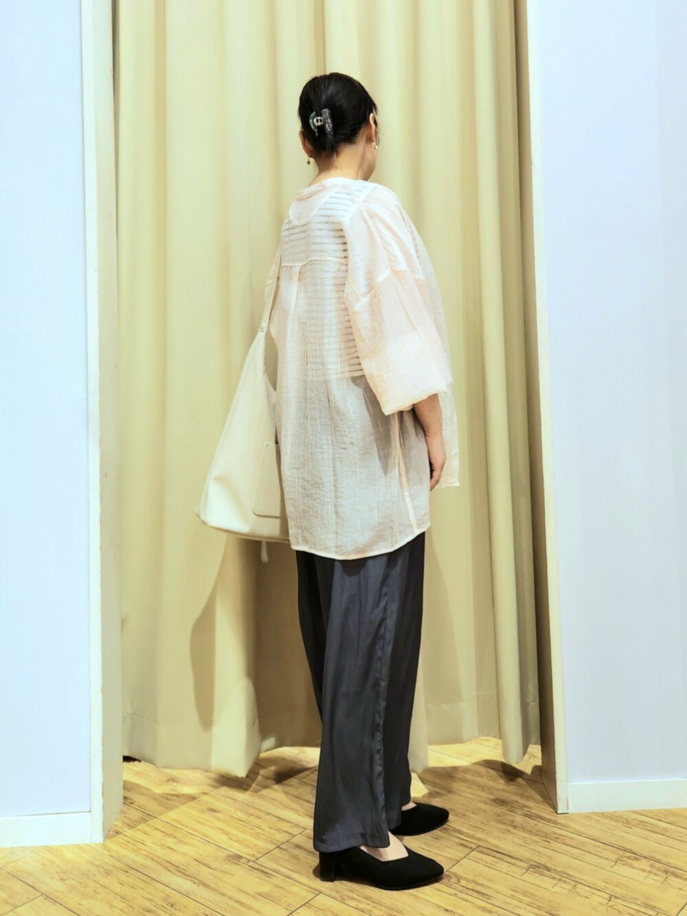 ブラック系のパンプス、グレー系のその他パンツ、ベージュ系のショルダーバッグを着用したレディースの春コーディネートの3枚目の写真