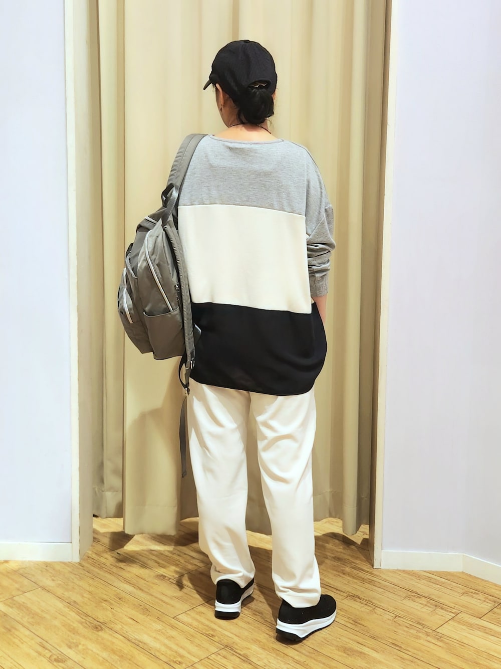 ブラック系のスニーカー、グレー系のバックパック/リュック、ホワイト系のその他パンツを着用したレディースの秋コーディネートの5枚目の写真