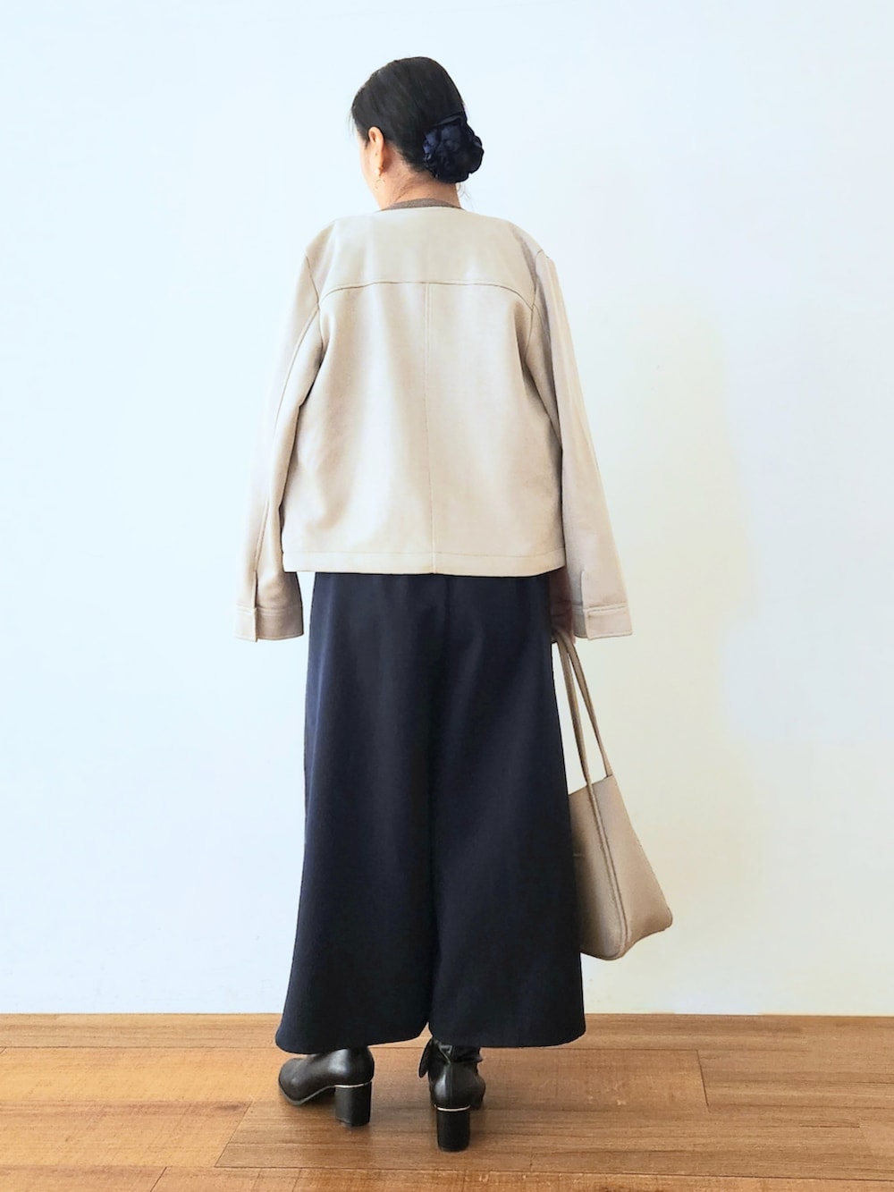 ブラック系のブーツ、ブルー系のその他パンツ、ブラウン系のニット/セーターを着用したレディースの秋コーディネートの3枚目の写真