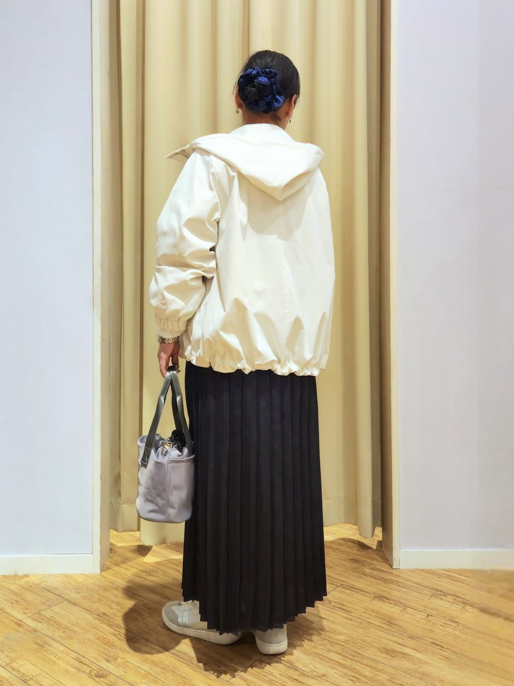 シルバー系のスニーカー、ブルー系のスカート、グレー系のショルダーバッグを着用したレディースの春コーディネートの4枚目の写真