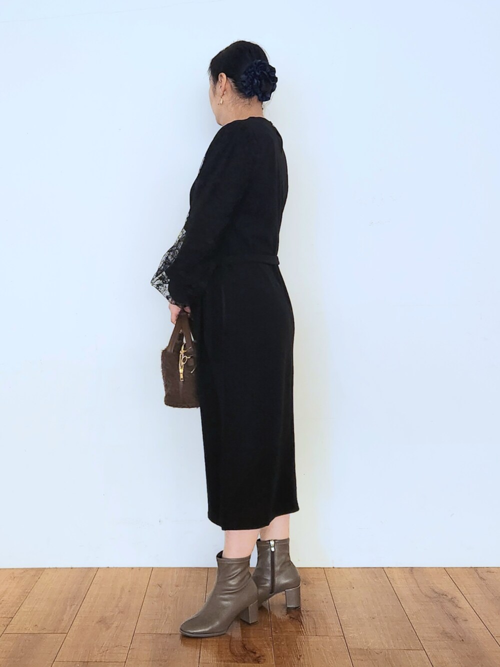 ブラウン系のブーツ、ブラック系のワンピース、ブラウン系のショルダーバッグを着用したレディースの秋コーディネートの5枚目の写真