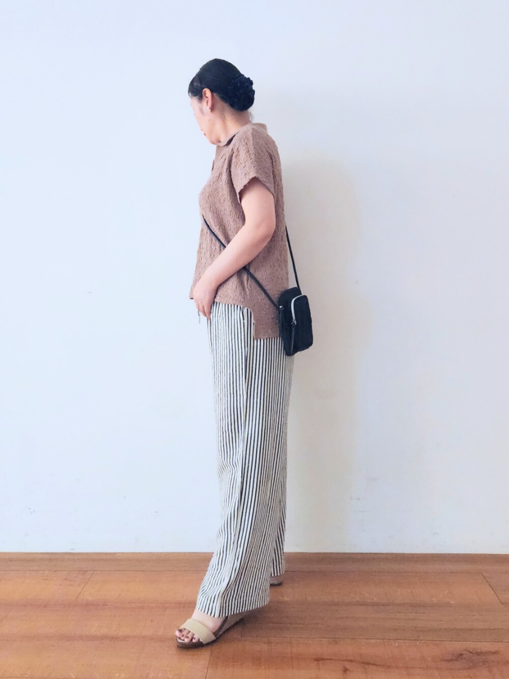 ゴールド系のサンダル、ブラック系のショルダーバッグ、ブルー系のその他パンツを着用したレディースの夏コーディネートの2枚目の写真