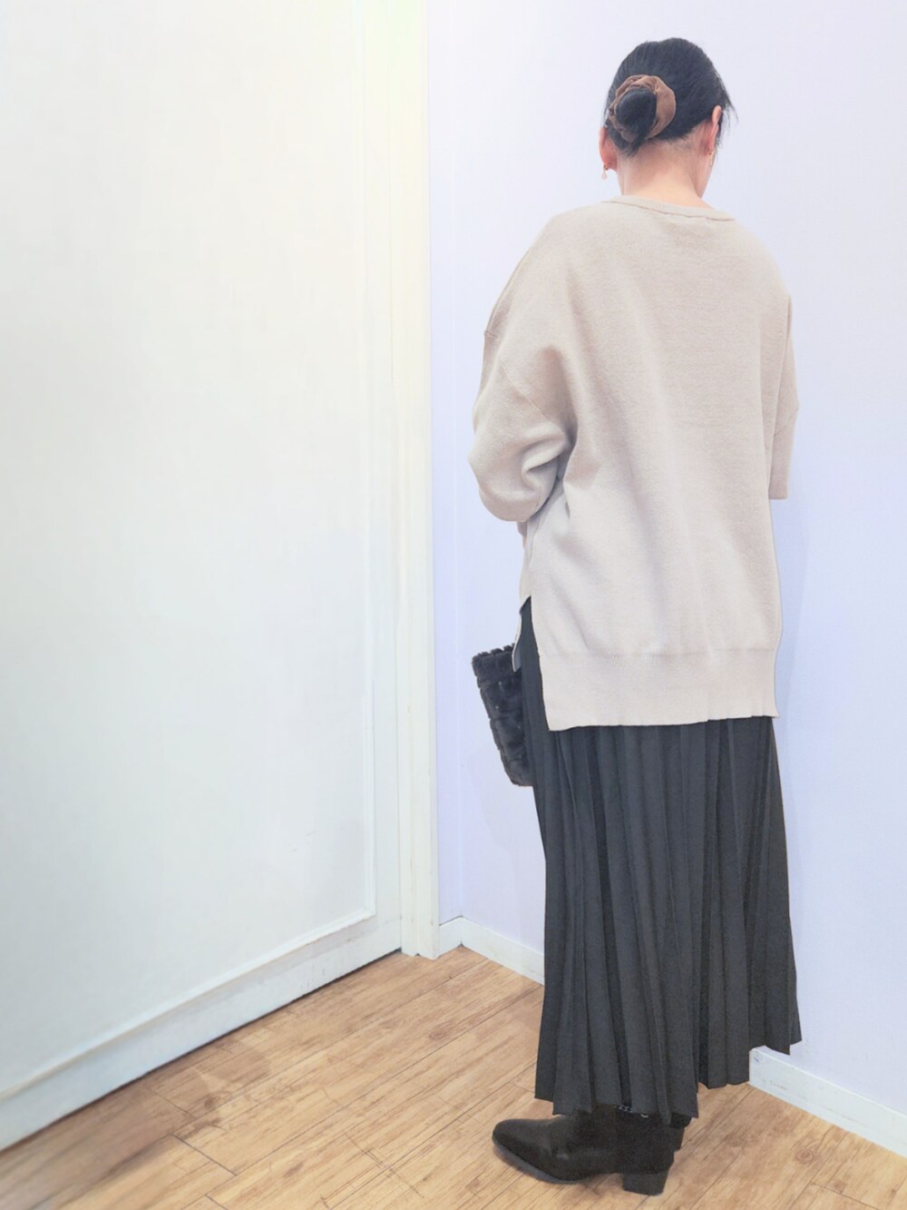 ブラック系のブーツ、ブラウン系のニット/セーター、ブラック系のスカートを着用したレディースの冬コーディネートの3枚目の写真