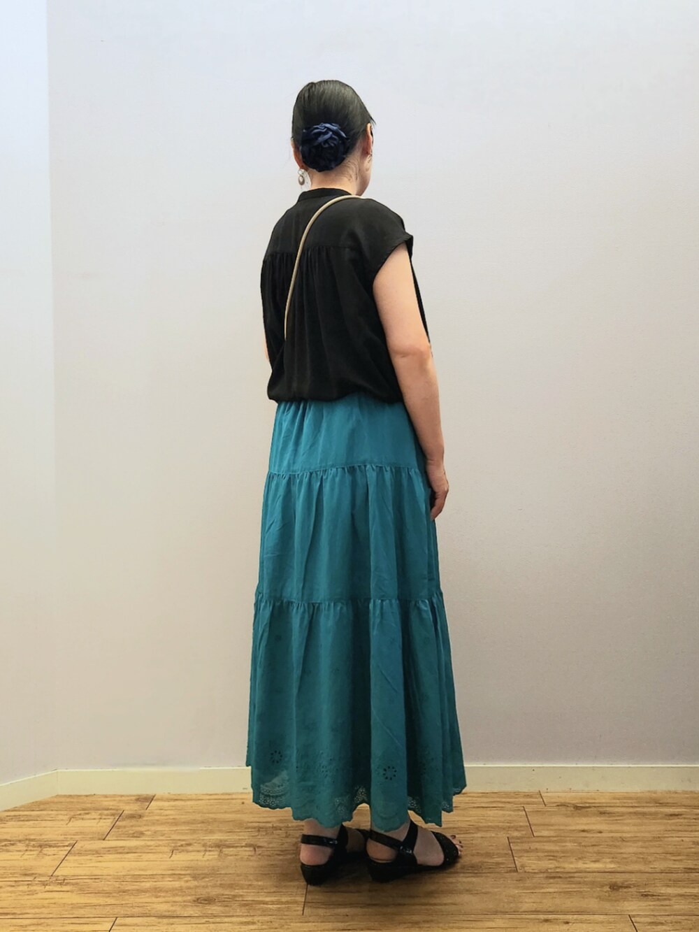 グレー系のショルダーバッグ、グリーン系のスカート、ブラック系のシャツ/ブラウスを着用したレディースの夏コーディネートの2枚目の写真