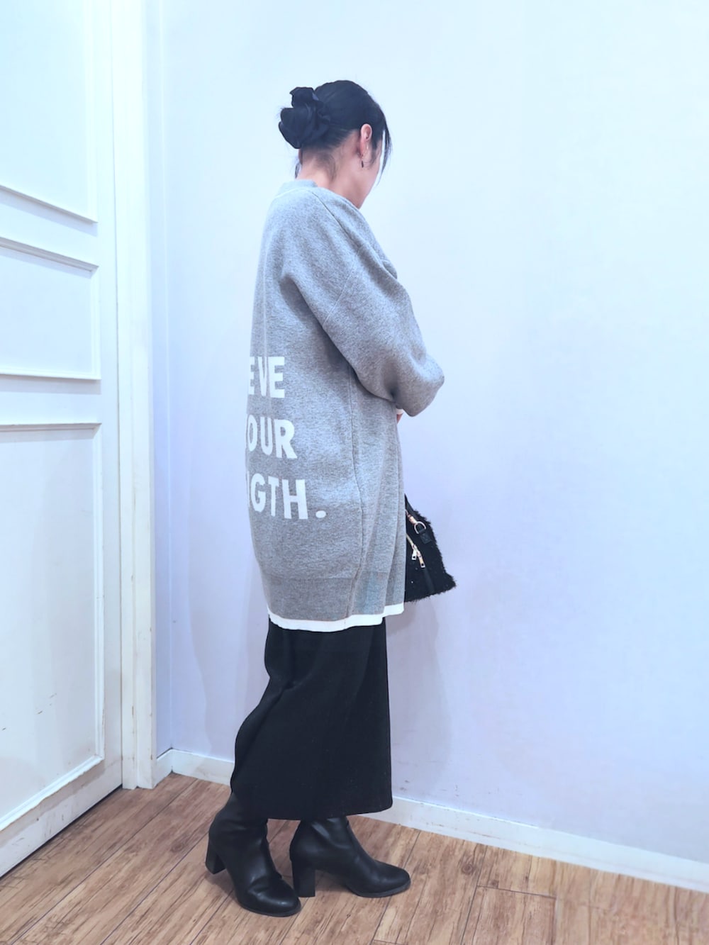 ブラック系のブーツ、ブラック系のスカート、ブラック系のショルダーバッグを着用したレディースの冬コーディネートの2枚目の写真