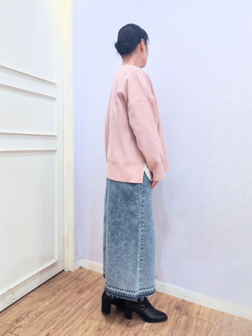 ブラック系のブーツ、ブルー系のデニムスカート、ピンク系のニット/セーターを着用したレディースの冬コーディネートの2枚目の写真