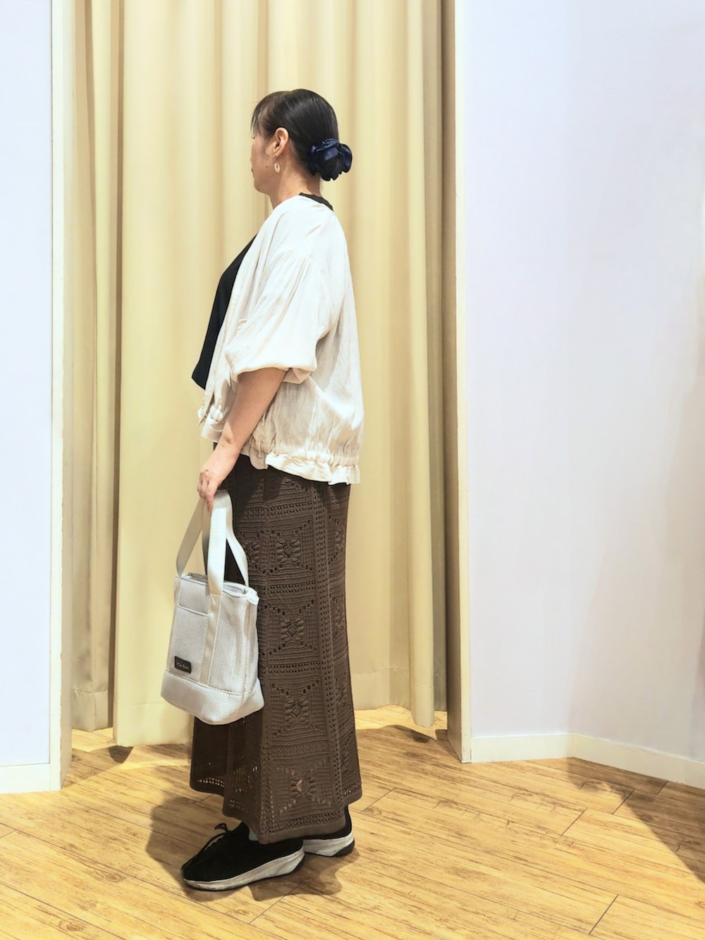 ブラック系のスニーカー、ブラウン系のスカート、ブラック系のTシャツ/カットソーを着用したレディースの夏コーディネートの3枚目の写真