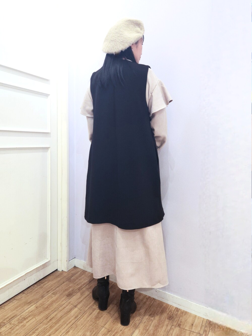 ブラック系のブーツ、ベージュ系のワンピース、ブラック系のベストを着用したレディースの冬コーディネートの3枚目の写真